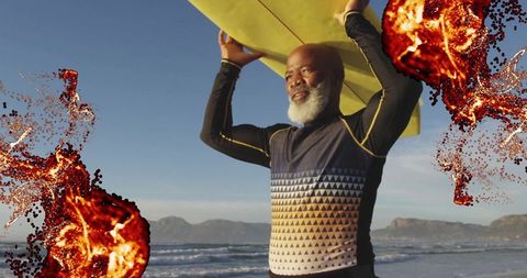 Mature surfer carrying yellow surfboard on scenic beach