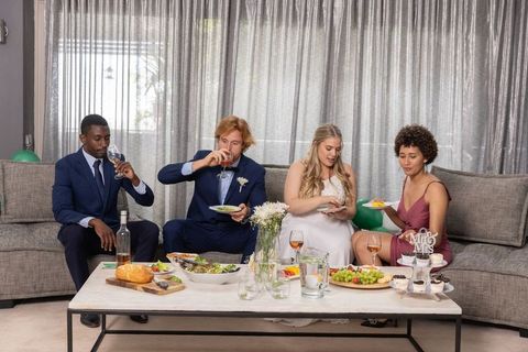 Elegant wedding party enjoying appetizers and wine in stylish lounge