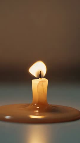 Melting taper candle burning and flame extinguishing in moody vertical video for relaxation