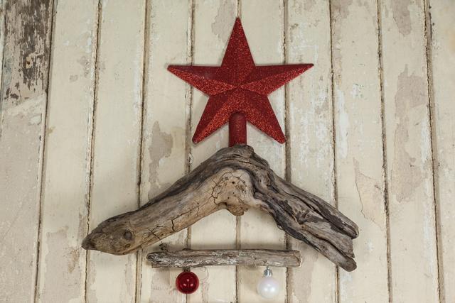 Rustic wooden Christmas tree crafted from driftwood, adorned with a red star topper and hanging ornaments. Ideal for holiday decor, DIY enthusiasts, and festive wall decorations. Perfect for adding a vintage touch to Christmas celebrations.