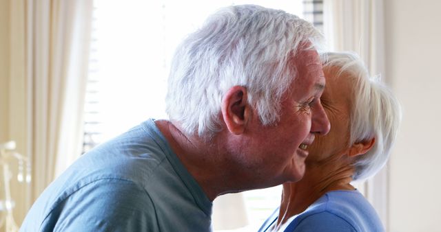 Senior couple kissing and interacting with each other at home