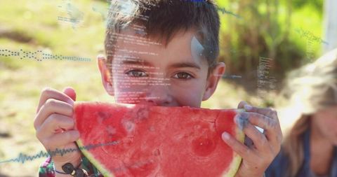 Boy eating watermelon outdoors with data overlay capturing summer joy and healthy snack