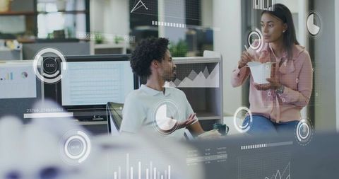 Colleagues sharing takeout while collaborating with digital analytics overlays in modern office