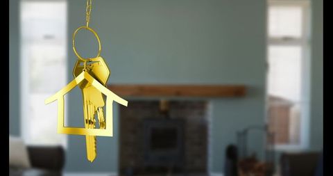 Golden house keychain suspended with modern living room backdrop