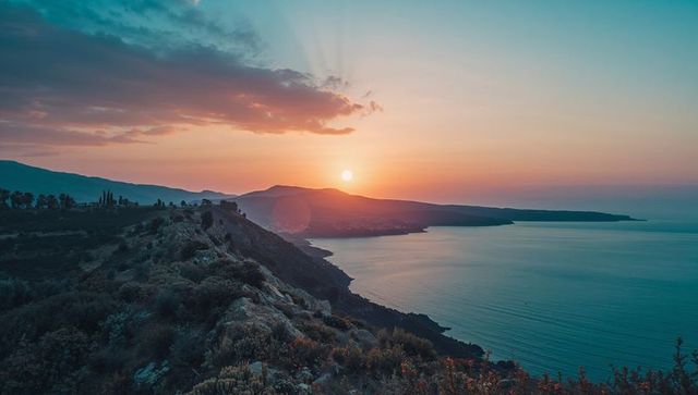 Serene Coastal Sunset Over Mountain Ridge and Ocean
