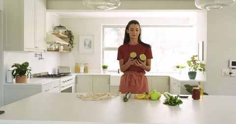 Woman in modern kitchen examining labels and fresh vegetables