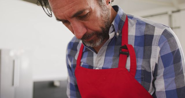 Middle-aged Man Cooking in Modern Kitchen Wearing Red Apron - Download Free Stock Images Pikwizard.com