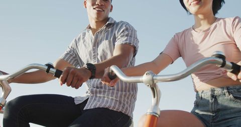 Couple Enjoying Bike Ride on Sunny Seaside Promenade