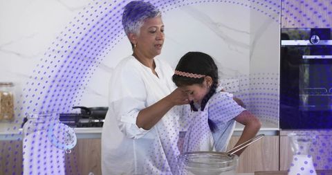 Grandparent guiding child while cooking in modern kitchen for family bonding and learning