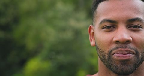 African American Man in Outdoor Serenity with Green Foliage Background
