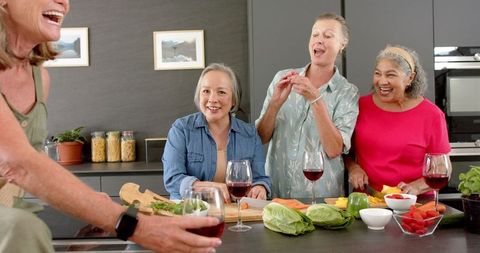 Senior Friends Celebrating Reunion Over Cooking and Wine