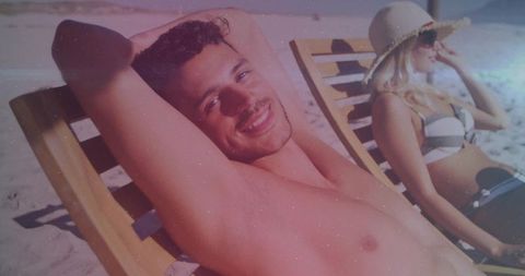 Smiling Couple Relaxing on Sunlit Beach Loungers