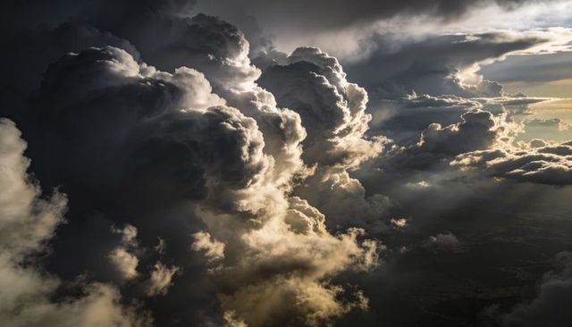 Dramatic Aerial Cumulonimbus Storm Clouds Rising with Crepuscular Rays and Dark Thunderhead