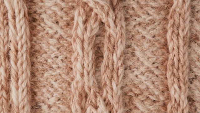 Beige cable knit close-up showing braided wool yarn texture for cozy fabric background