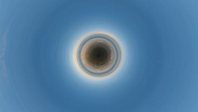 Tiny-planet coastal city featuring circular waterfront and glowing horizon ring at dusk