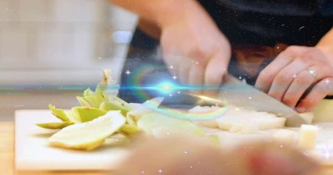 Home cooking hands chopping vegetables with warm lens flare and rainbow bokeh