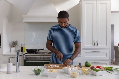 Man Slicing Mushrooms on Modern Kitchen Island