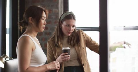 Diverse Colleagues Collaborating with Technology in Bright Office