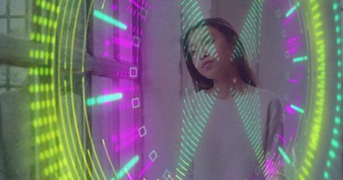 Chinese woman gazing through window with neon holographic rings, futuristic contemplation