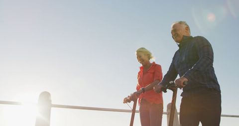 Senior Couple Enjoying Scooter Ride on Sunny Promenade