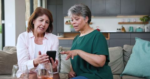 Mother and Daughter Engaged in Smartphone Conversation