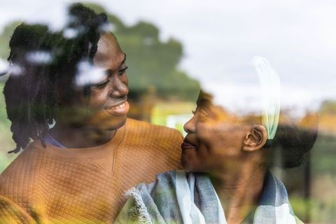 Warm intimate moment between african american couple sharing smile through cafe window