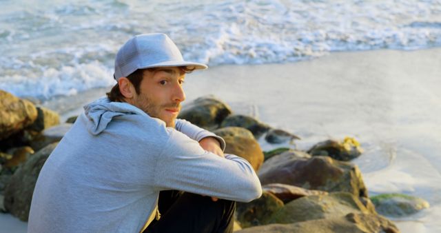 Young Man Relaxing on Rocky Beach at Sunset - Download Free Stock Images Pikwizard.com