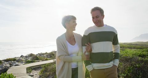 Senior Couple Enjoying Romantic Coastal Walk in Sunlight