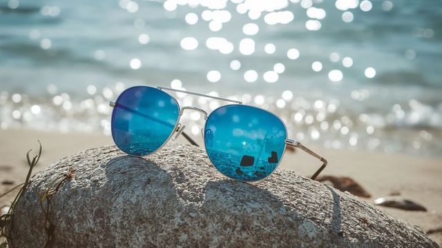 Beach reflections with stylish blue aviator sunglasses