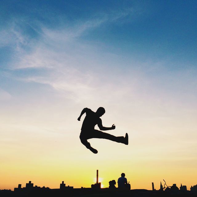 Silhouette of Person Jumping Against Vibrant Sunset Sky - Download Free Stock Photos Pikwizard.com