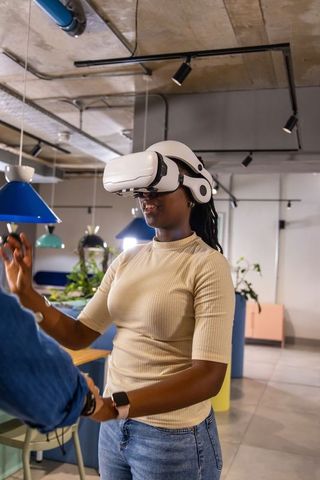 African American Woman Testing VR Headset in Modern Coworking Space for Team Demo
