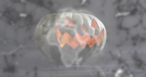 Glowing carved pumpkin emitting warm orange light and swirling fog with glossy reflection