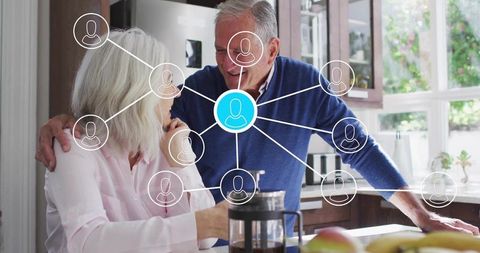 Senior couple connecting with family network at sunlit kitchen counter