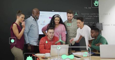 Collaborating multicultural team gathered around laptop reviewing AR dashboards and analytics