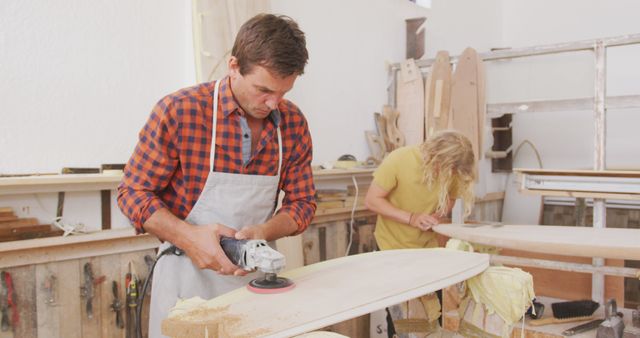 Focused Woodworkers Crafting Surfboards in Workshop - Download Free Stock Images Pikwizard.com