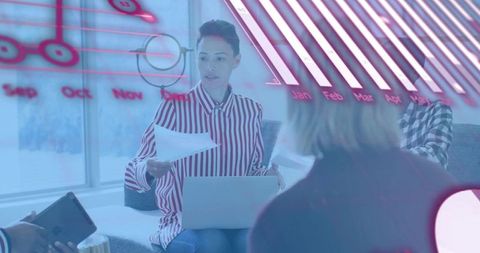 Female leader presenting data dashboards and charts on laptop during collaborative team meeting