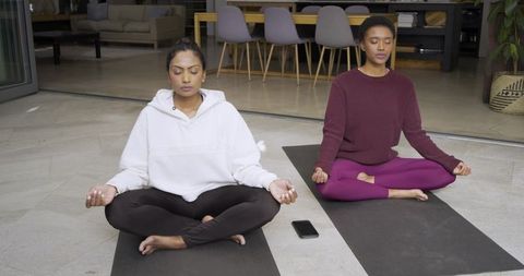 Diverse Female Friends Meditating Outdoors on Home Patio