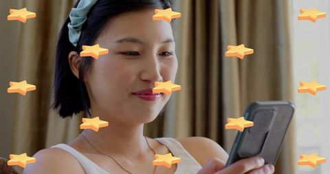 Korean woman relaxing on sofa scrolling smartphone surrounded by playful star stickers