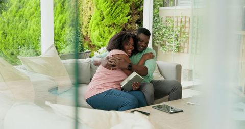 Happy Couple Relaxing on Patio with Tablet