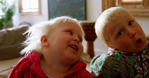 Caucasian Siblings Relaxing and Smiling at Home