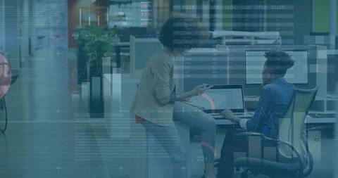 Collaborating on data dashboards in modern open-plan office with laptops and analytics