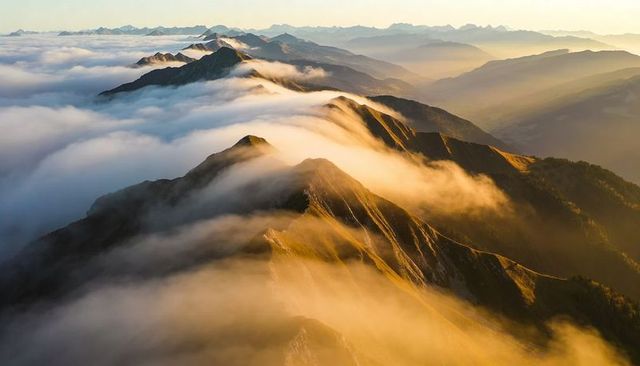 Sunrise Fog Rolling Over Jagged Alpine Ridge and Mountain Panoramic Crest at Dawn with Golden Light
