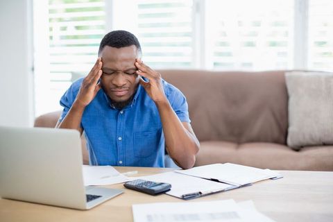 Stressed man facing financial problems in home office