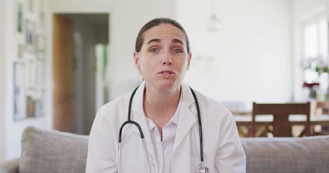 Happy Female Doctor Video Calling from Home With Stethoscope
