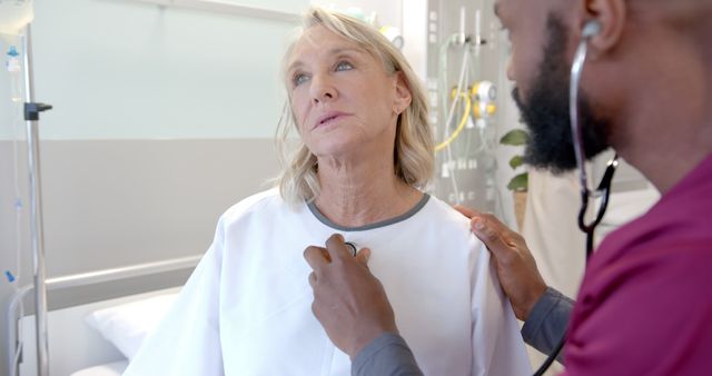 Doctor using a stethoscope to listen to an elderly patient's heart in a hospital setting, signifying medical care and healthcare services.