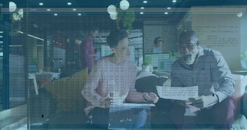 Collaborating Team Reviewing Laptop and Documents in Modern Office with Code Overlay
