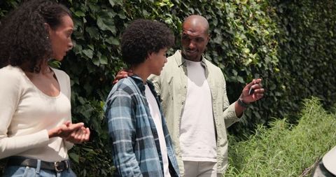 Family Bonding Outdoor Stroll with Teen by Lush Greenery