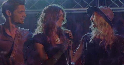 Musicians performing on stage smiling and collaborating