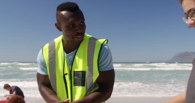 Lifeguard Wearing Yellow Safety Vest on Sunny Beach - Download Free Stock Images Pikwizard.com