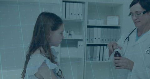 Pediatrician consulting young patient with medicine in clinic